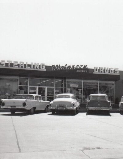 A Black and White Photograph of Cars Parked Outside of the Original Sterling Drug Store