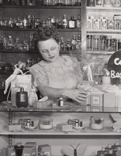 A Photograph of a Woman Standing Behind the Counter at the Original Sterling Drug Store.