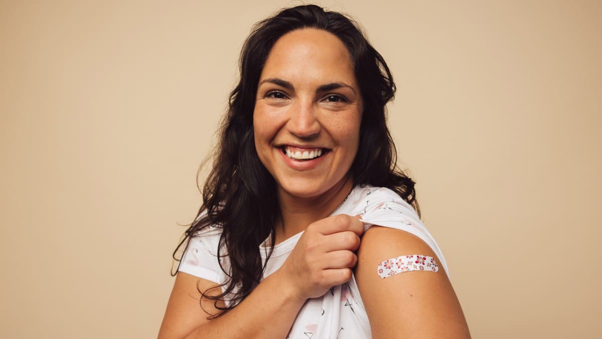 Woman displaying bandaid from a flu shot